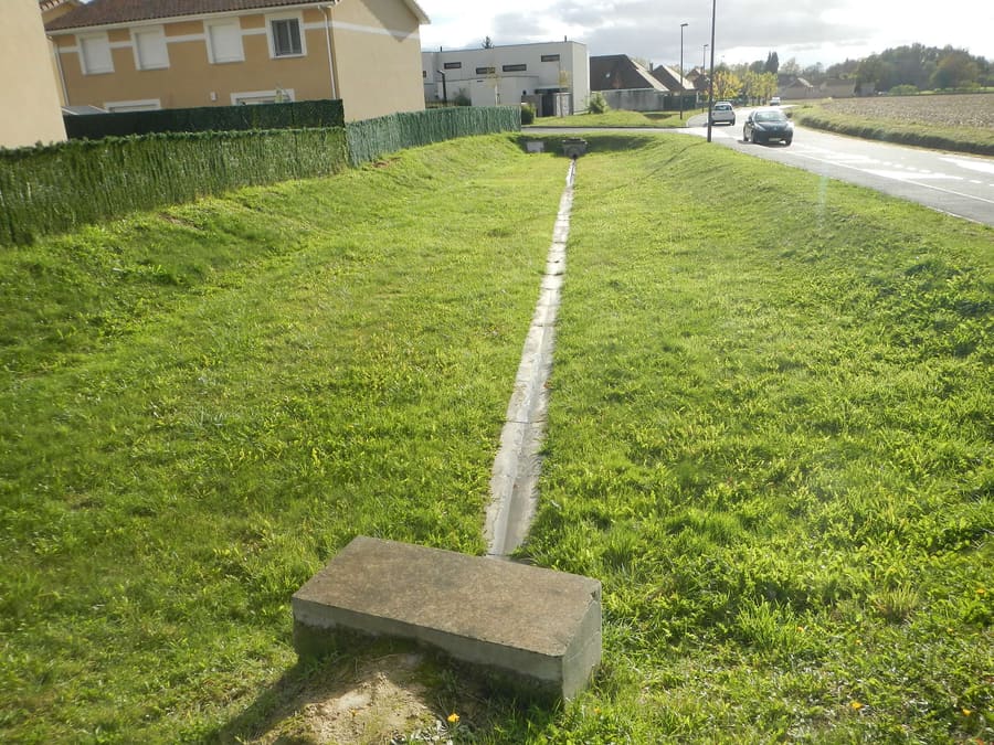 Noue enherbée de gestion des eaux pluviales dans un lotissement.